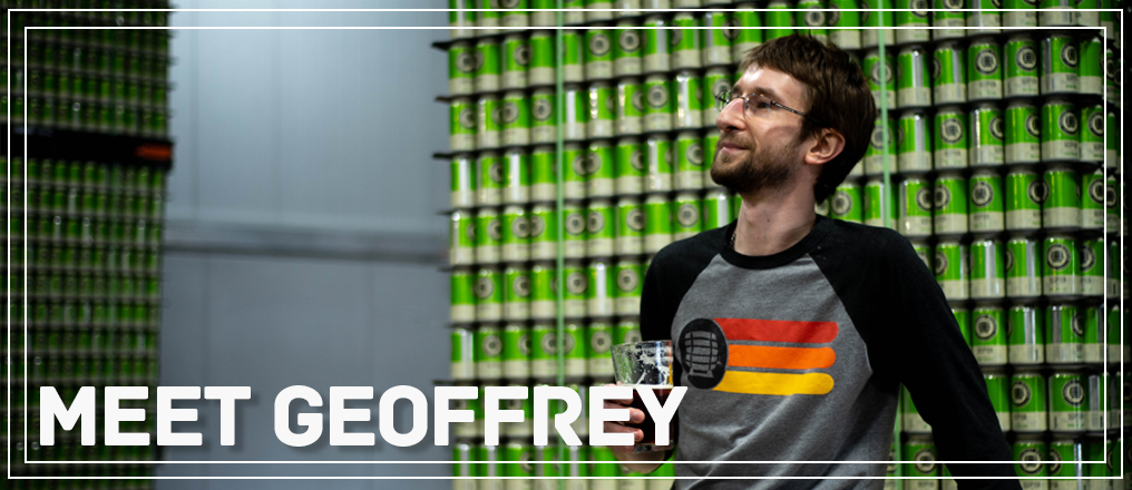 Our employee Geoffrey sitting before a stack of Scepter cans.